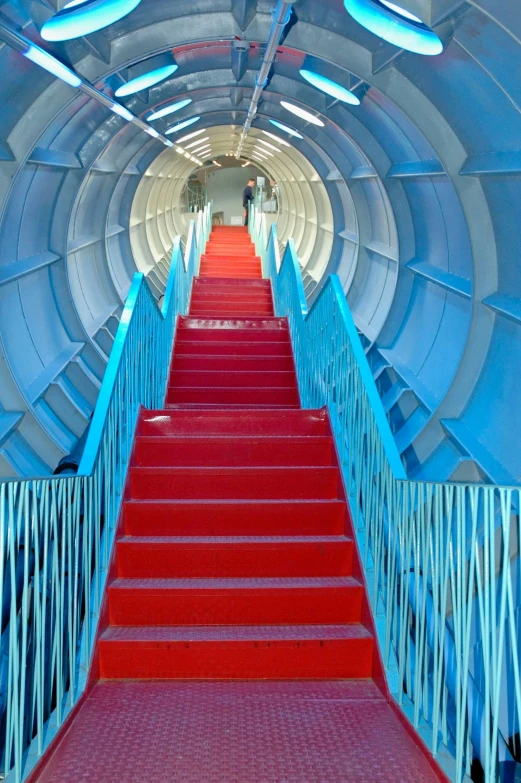 a red carpeted staircase is next to white walls