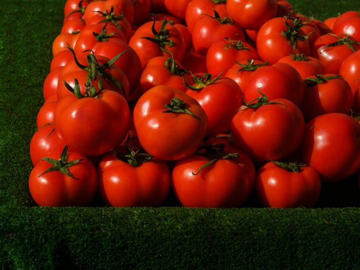 the red tomatos are stacked on top of each other