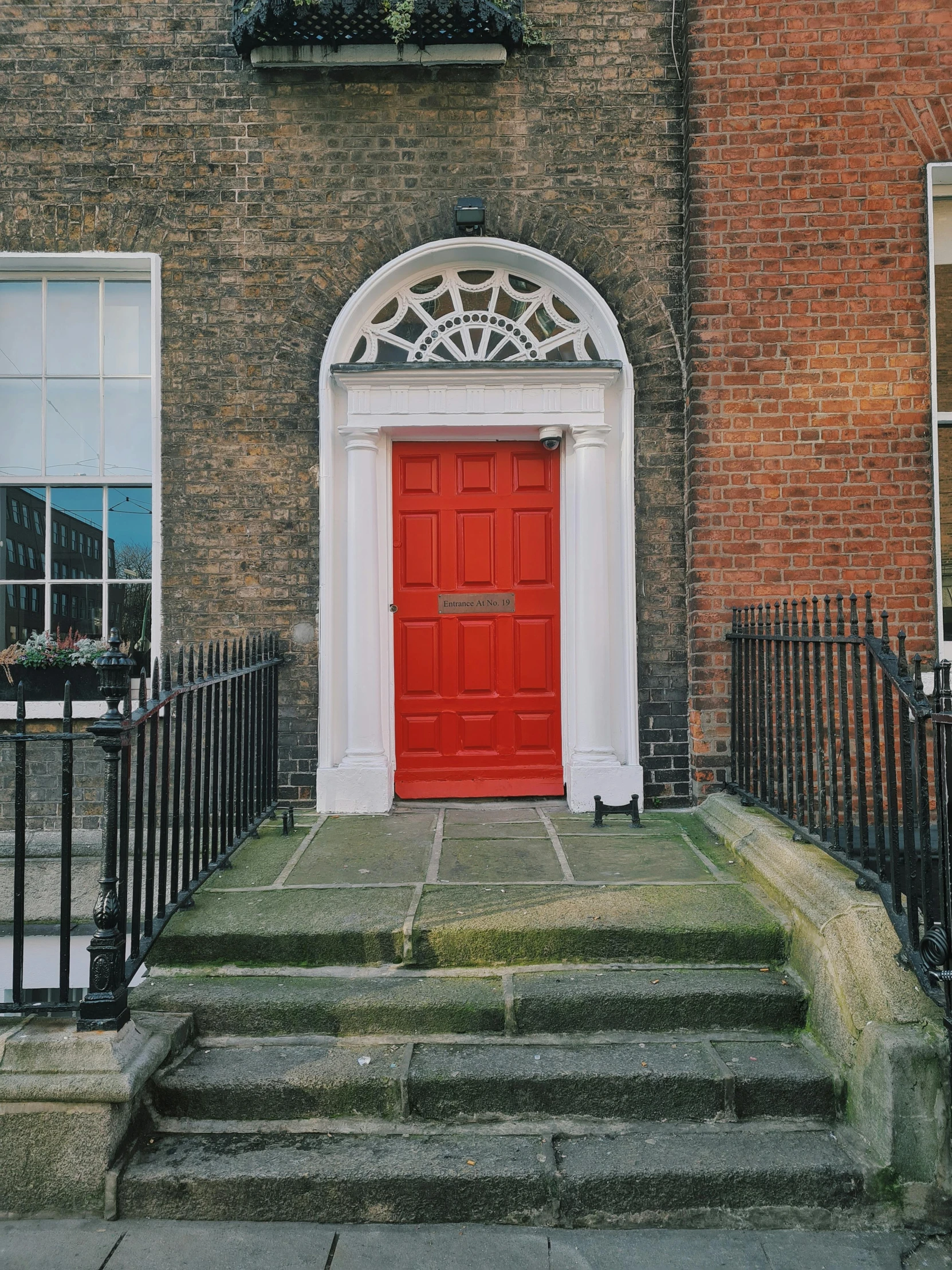 a set of steps leading to a red door and window