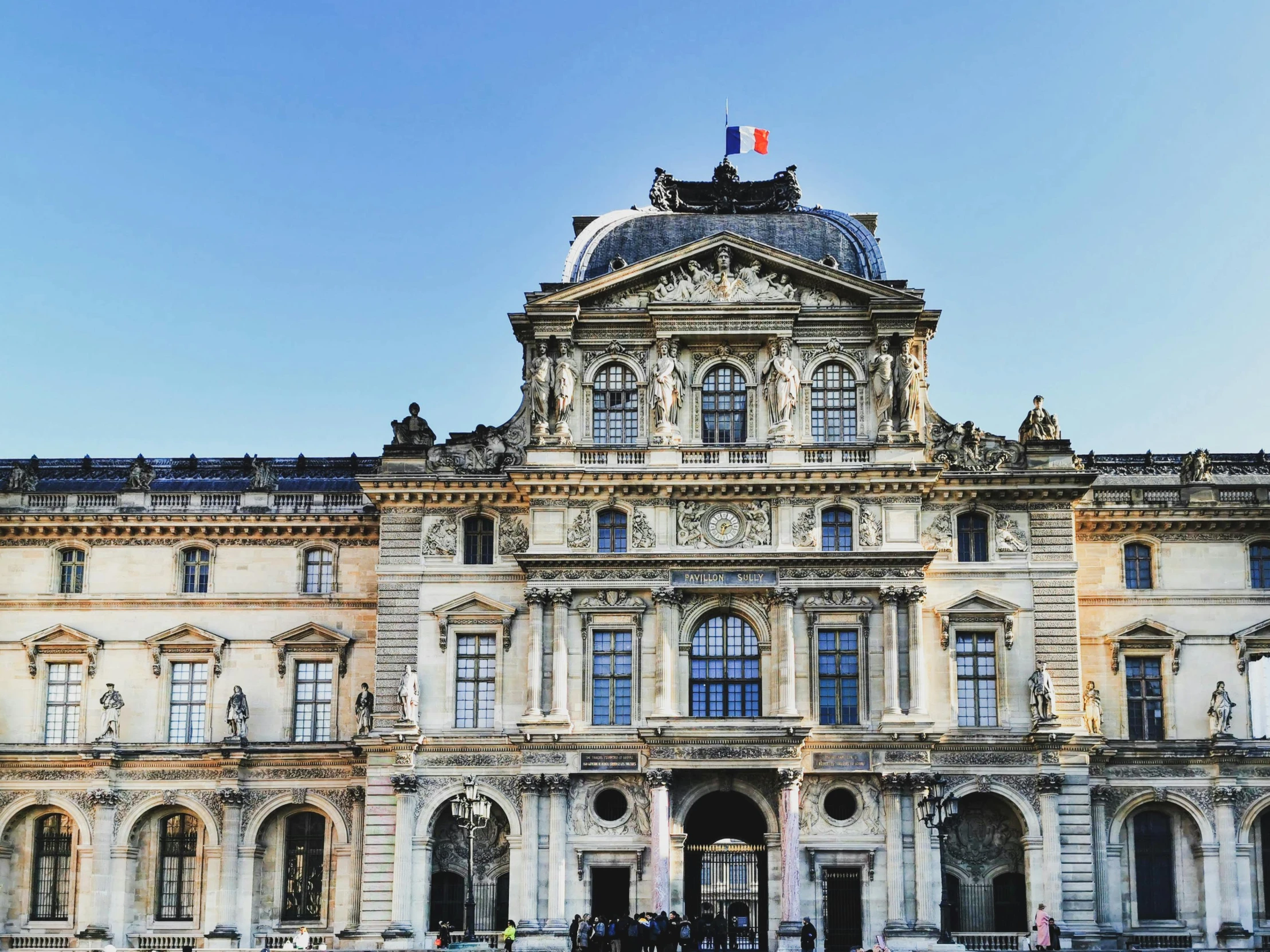 an older looking building that is surrounded by people