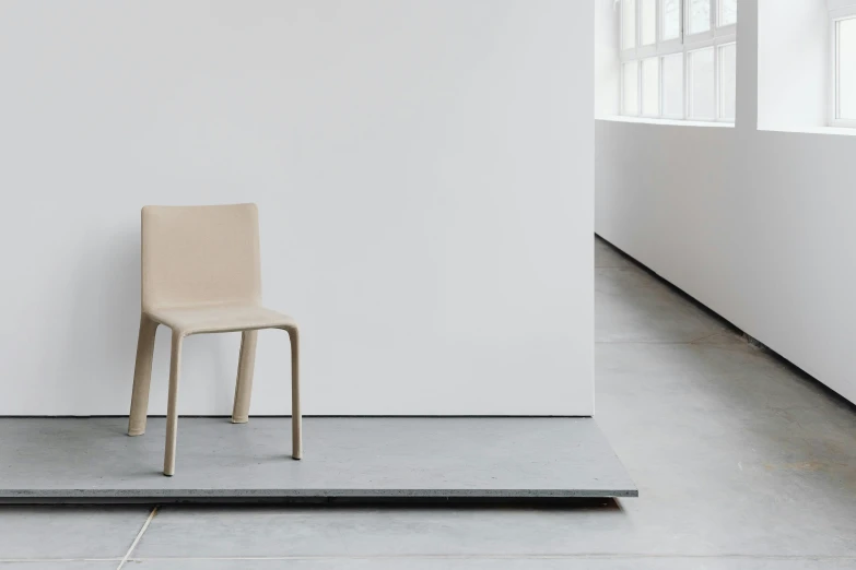 a chair in front of a wall by an open window