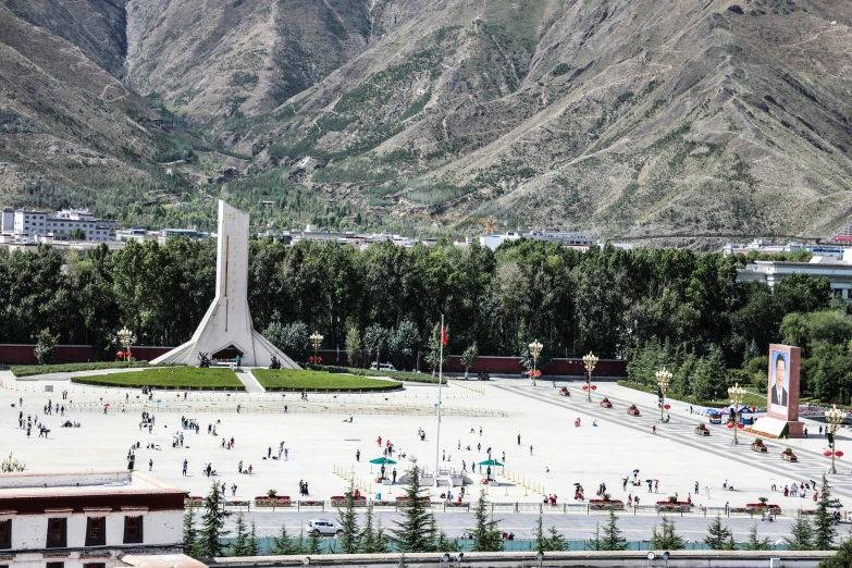 many people are around an area with mountains in the background