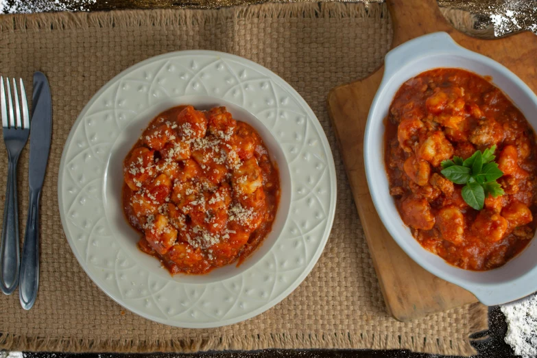 three white dishes with tomato sauce and pasta