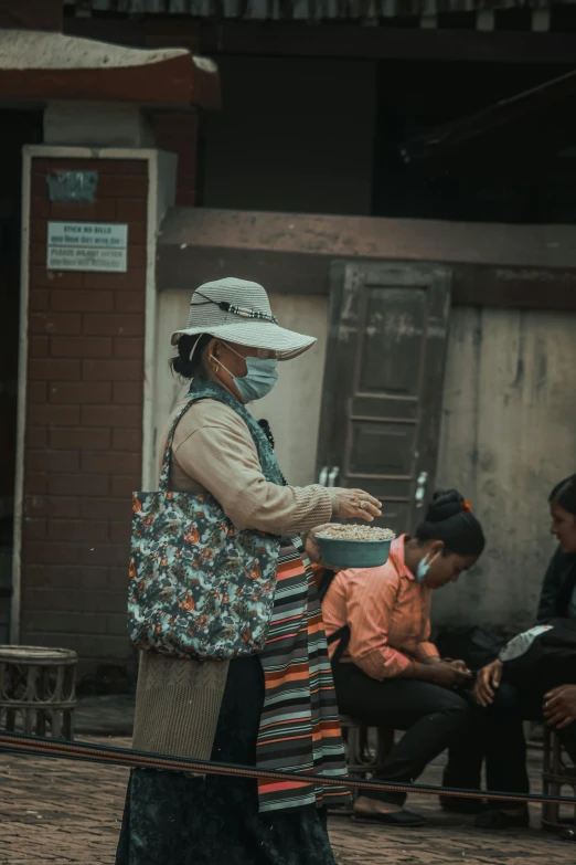 a woman in a mask standing next to other people