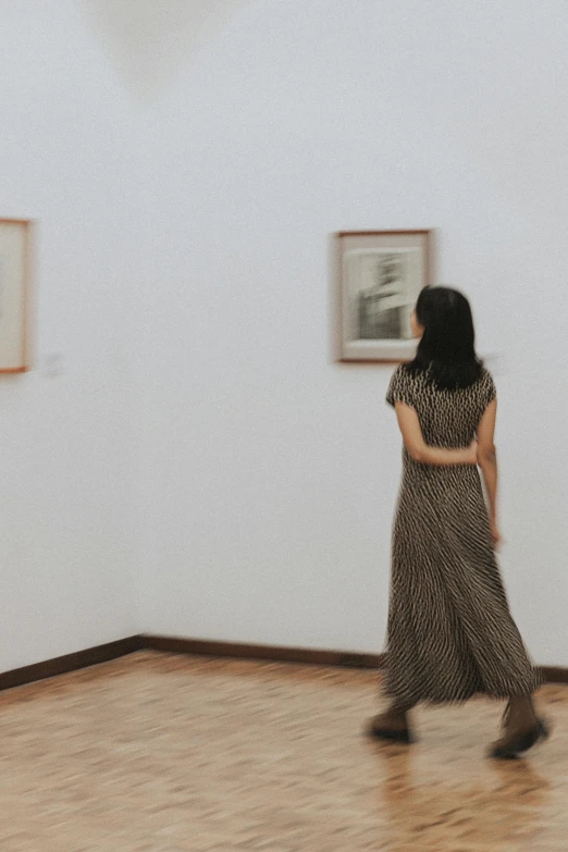 the woman in a dress is running through an empty room
