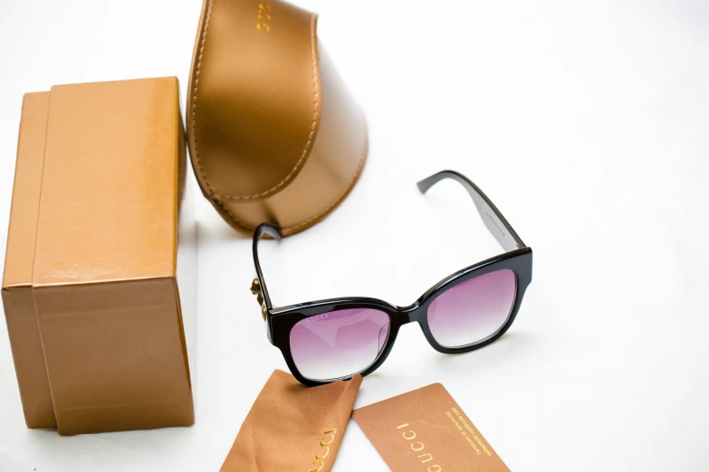 sunglasses are next to a box and a pair of glasses
