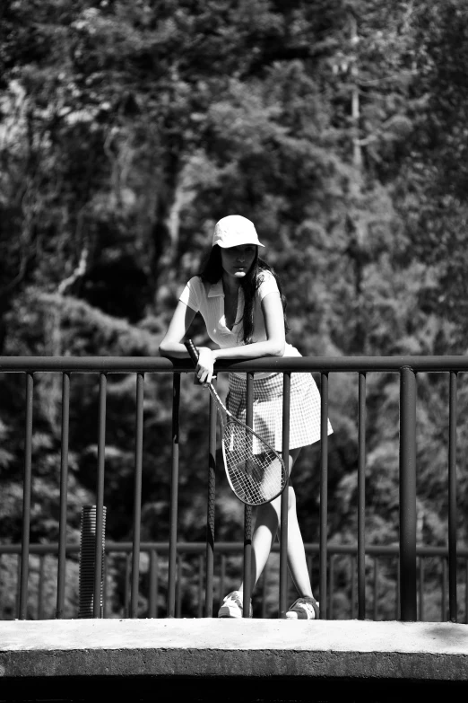 a woman sitting on top of a bench holding a racquet