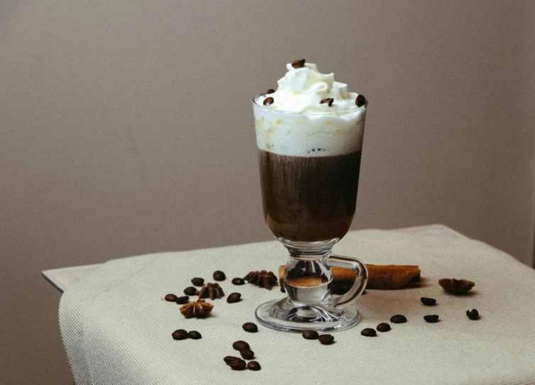 a glass full of some liquid with some coffee chips on top