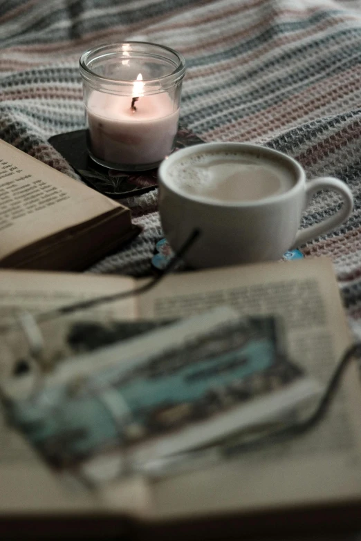 cup of coffee with a candle and an old book