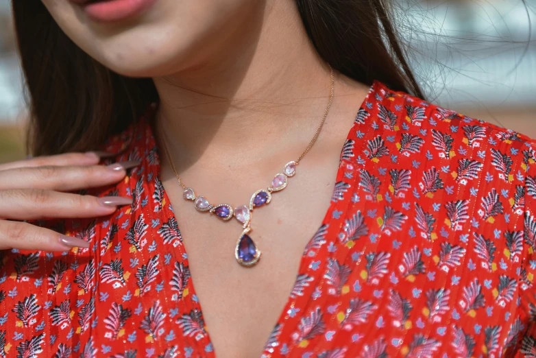 a woman wearing a necklace with an oval ayst design