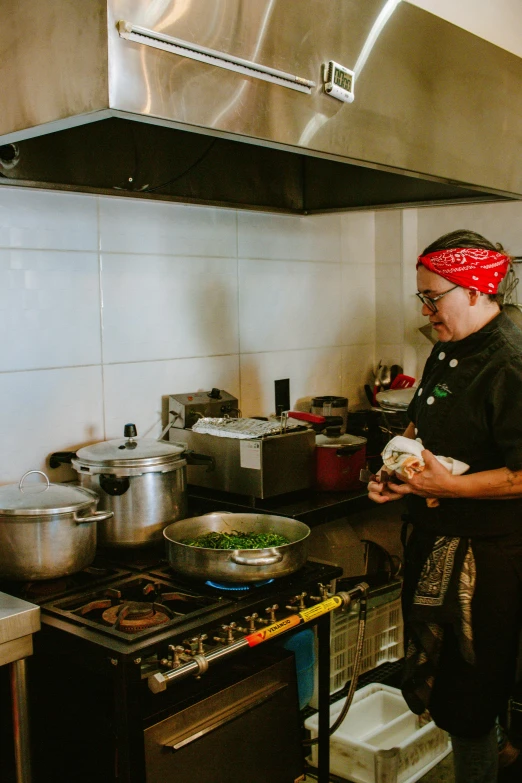 a male in black jacket a stove and pans