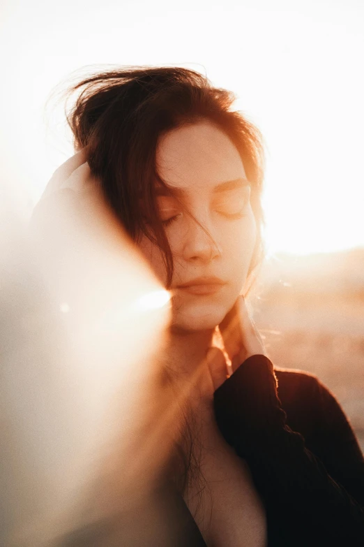 a woman is touching her face behind her hands