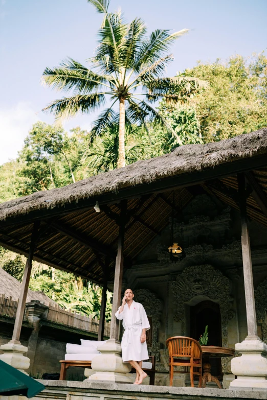 an old woman posing outside a small hut