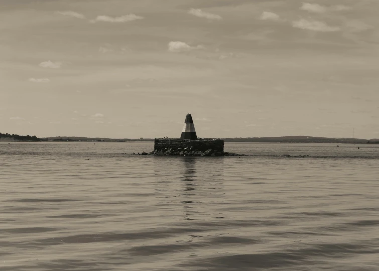 the lighthouse is in the middle of the ocean