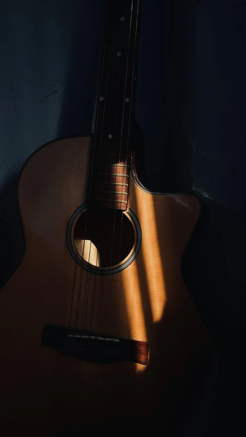 an acoustic guitar hanging on a wall