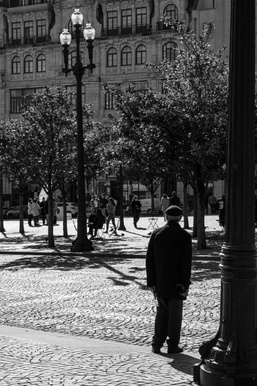 a man that is standing next to a lamp post