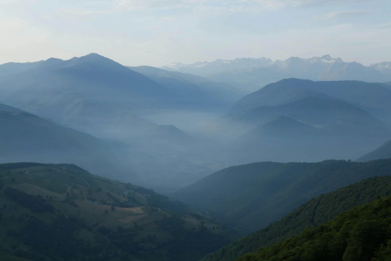 view from the top of a mountain to foggy valleys below