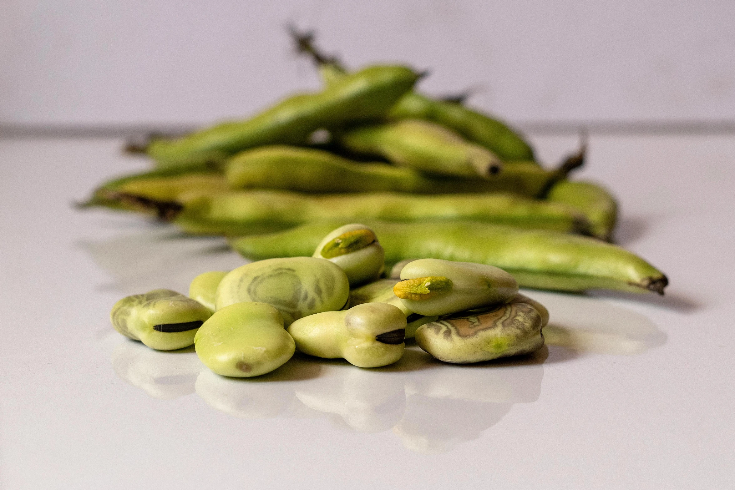 some green bananas on top of a white table