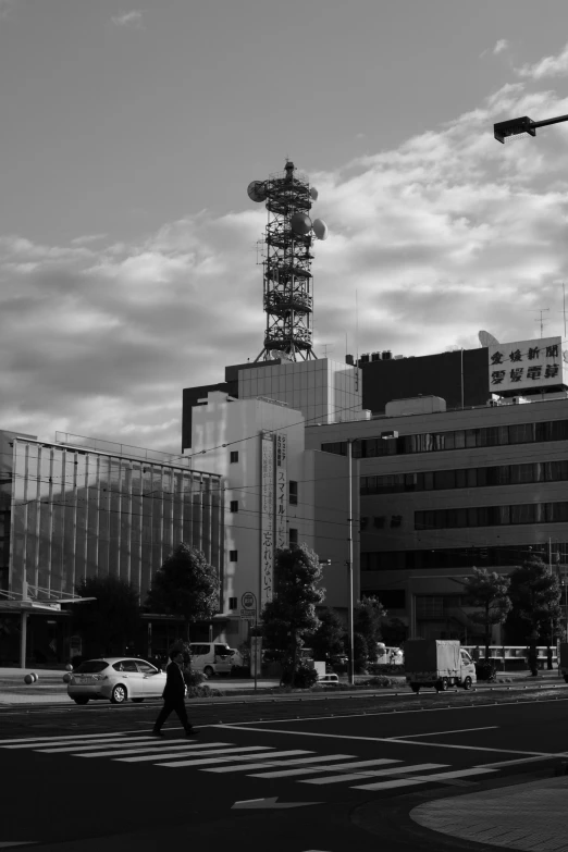 people crossing the street in front of some buildings