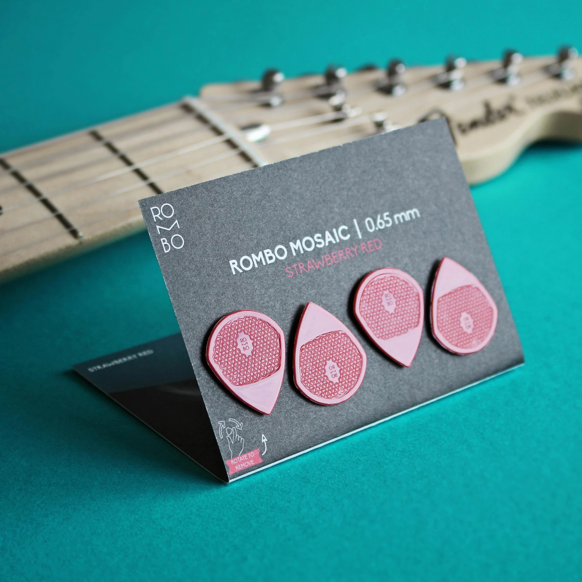 two pink heart shaped paper clips attached to an electric guitar