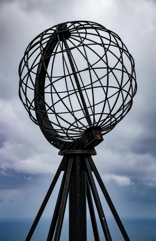 a large metal pole with a globe at top