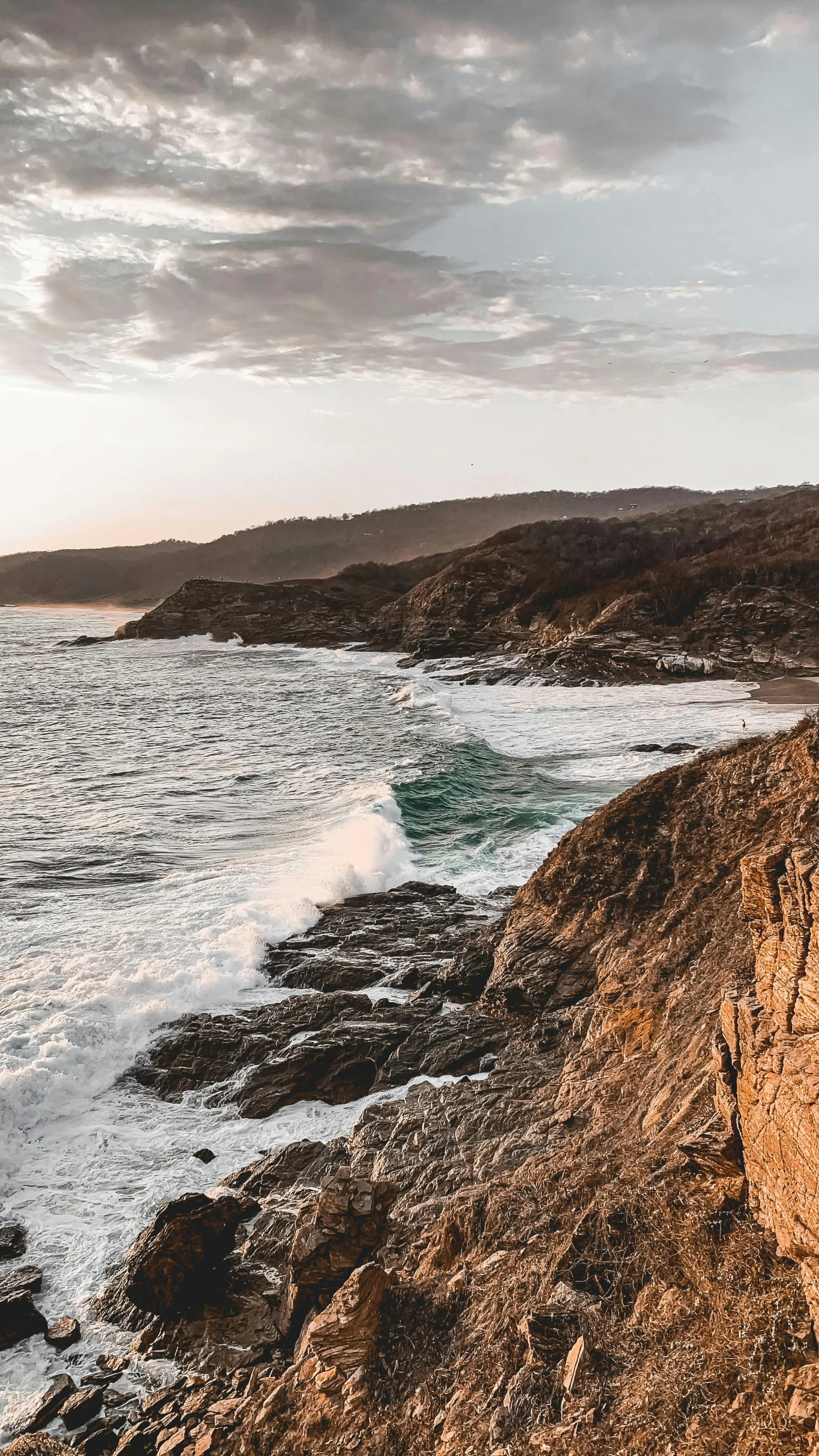 some ocean waves crashing over the top of a hill