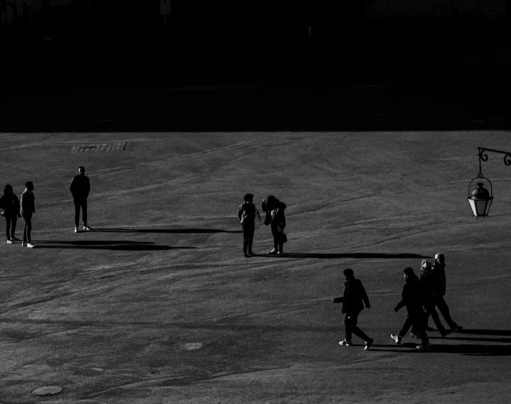 a group of people walking across a field next to a kite