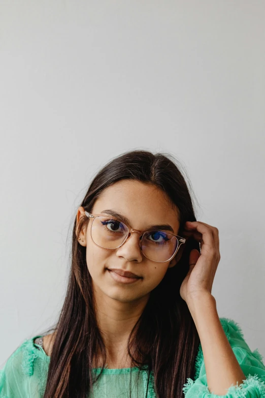 a young woman wearing blue and green wearing eyeglasses