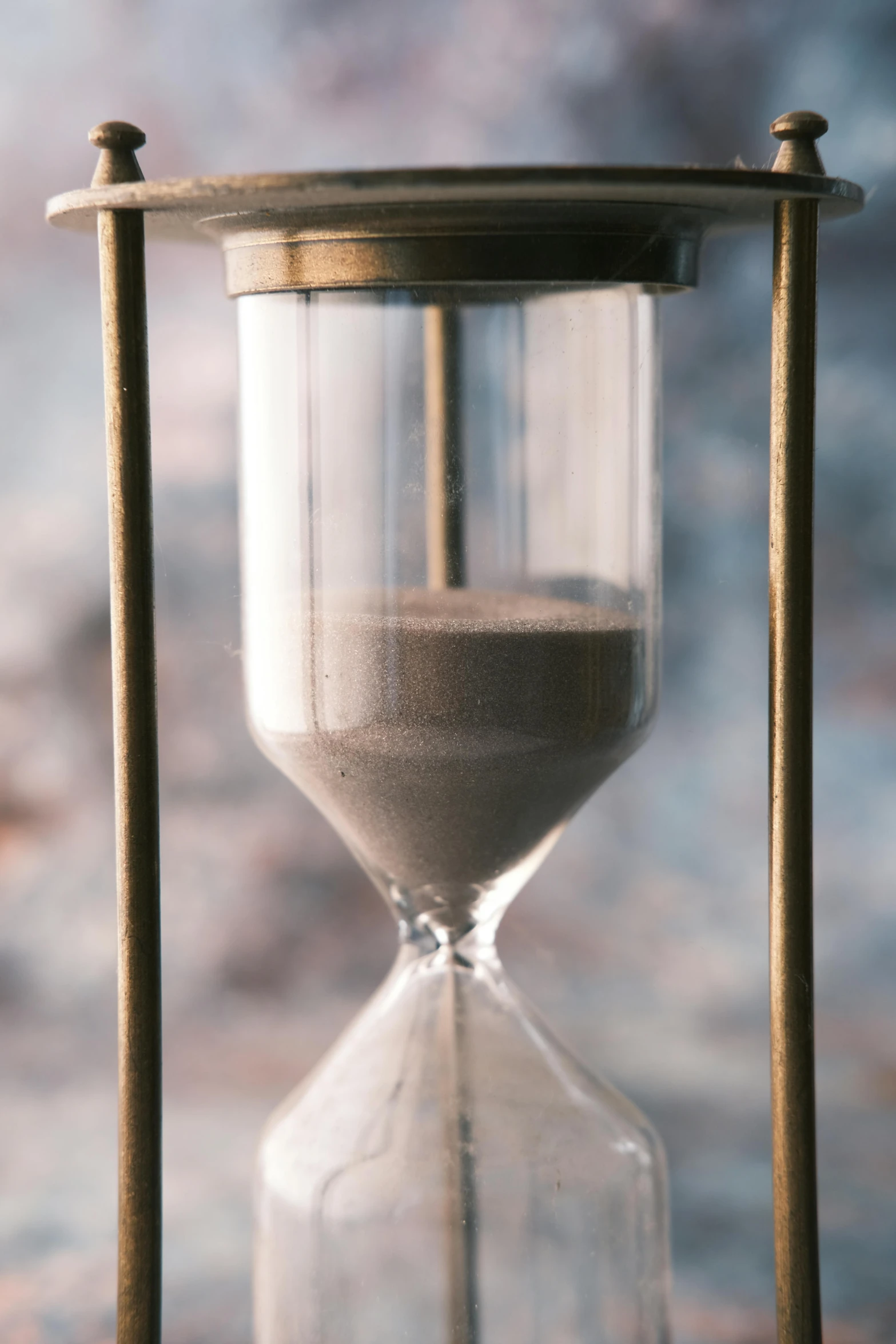 an hourglass with two wooden sticks and a sand glass