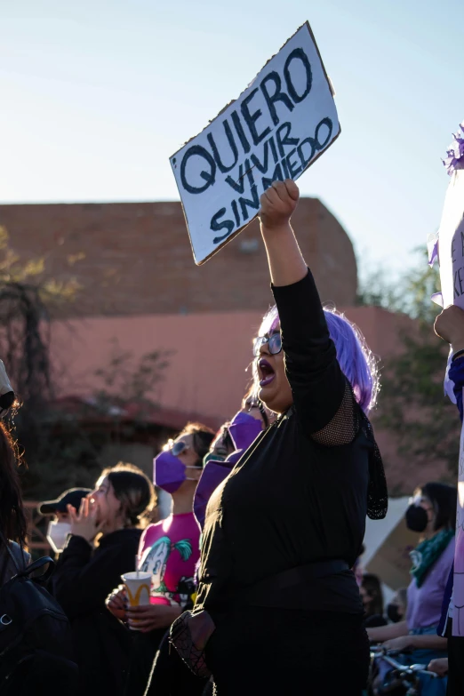 a woman in black holding up a sign