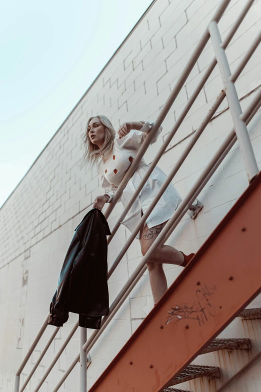 a woman standing on a stairs next to a metal rail