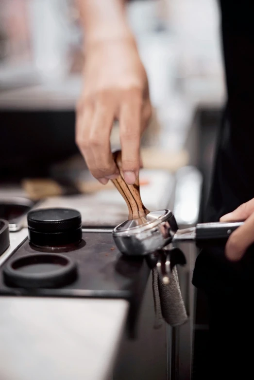 a man holds several forks above an induction stove burner