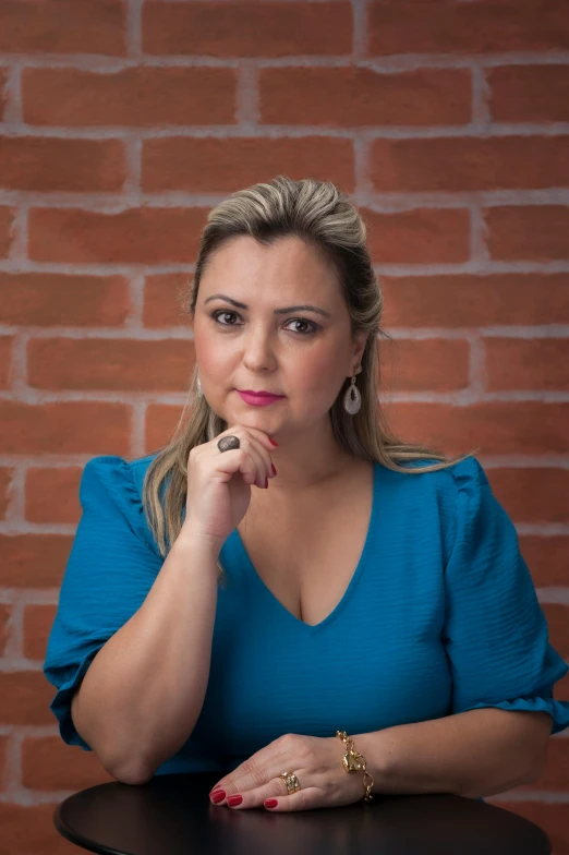 a woman in a blue top sitting in front of a table