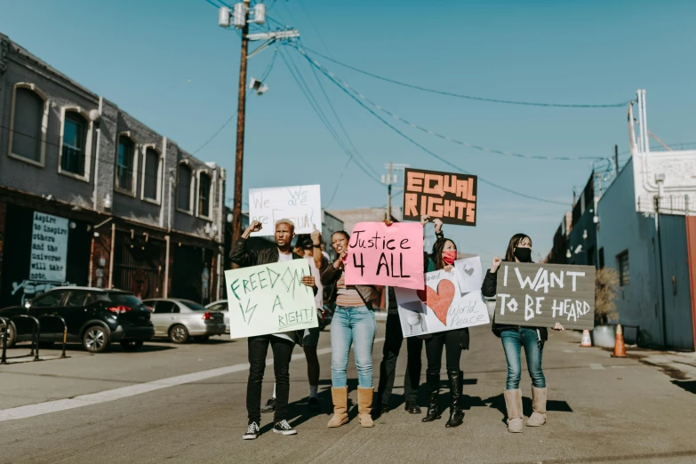 group of people holding up signs standing next to each other