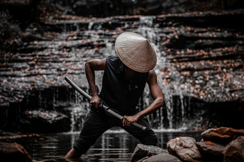 a man with a straw hat holding two water spears