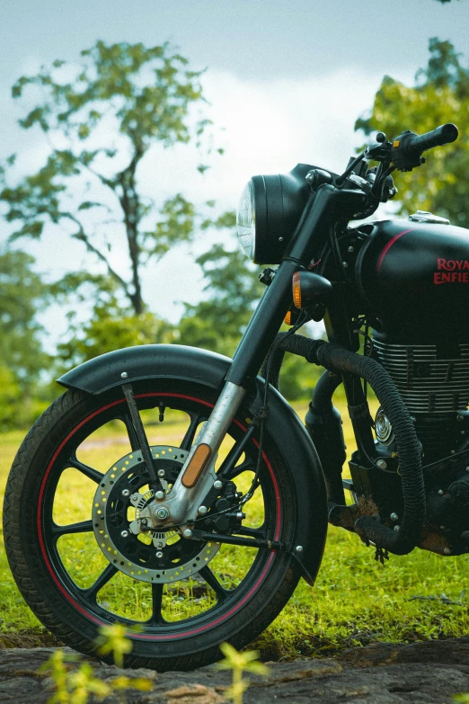 black motorcycle on grassy area near wooded area