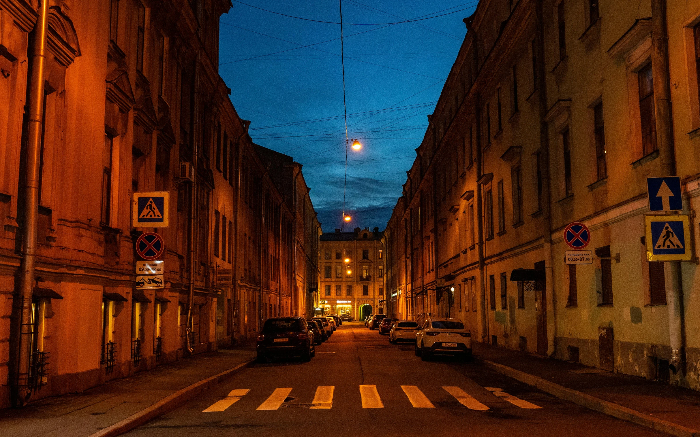 a street with cars parked on both sides and a street light on