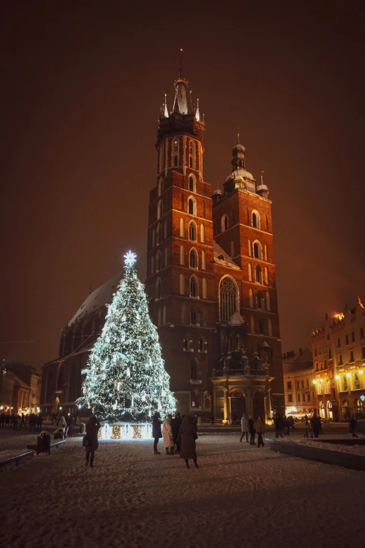 two tall christmas trees in front of a large building