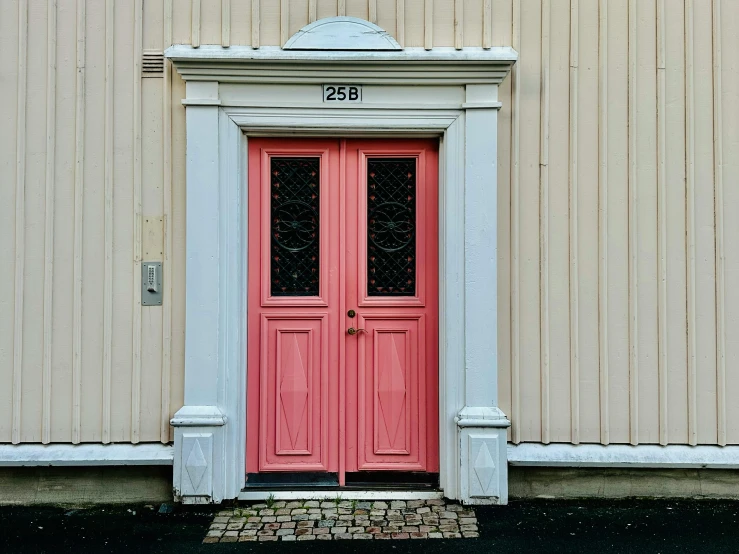 a red and white door is shown in front of a tan building