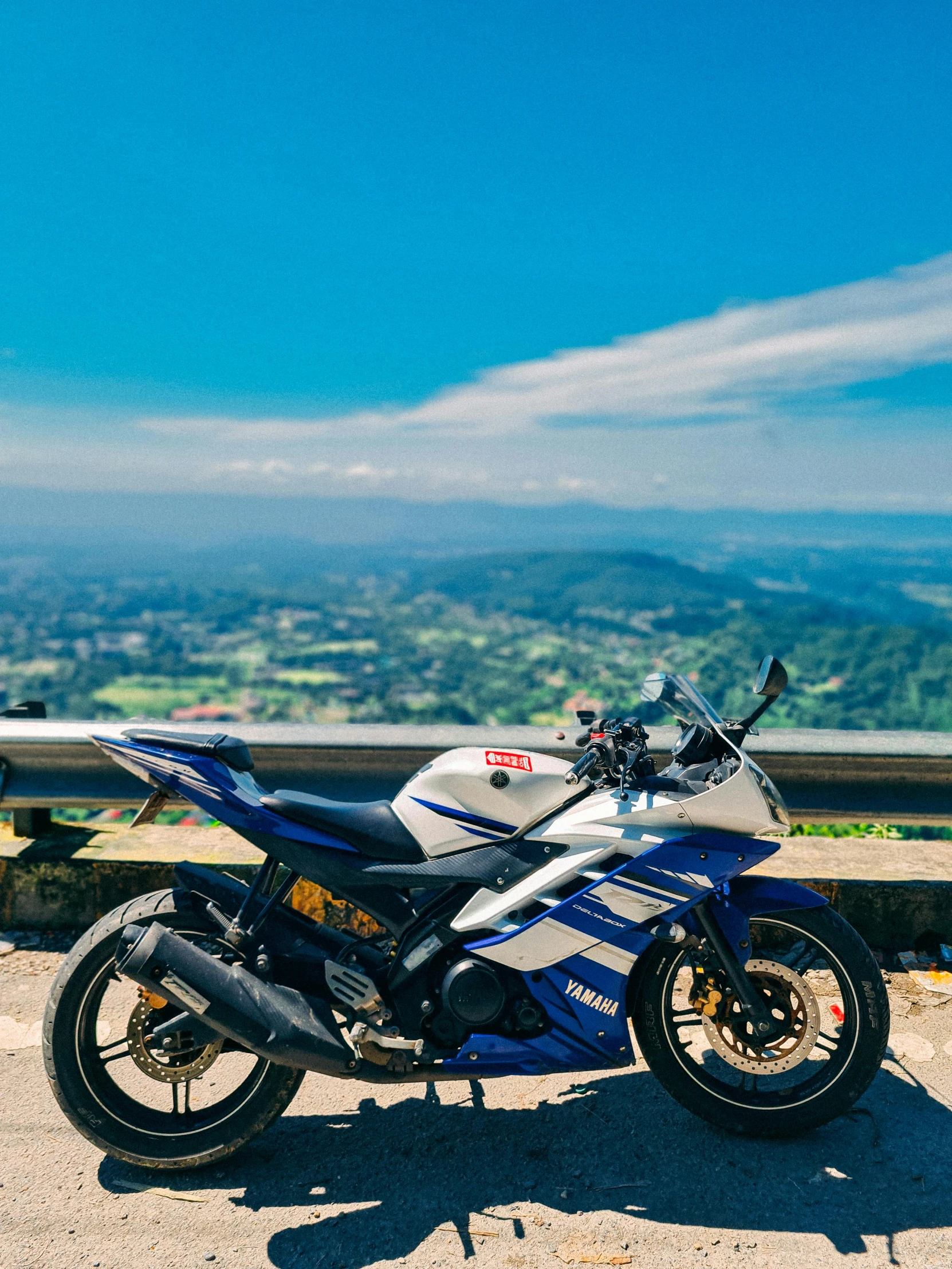 a blue and silver motorcycle sitting on top of a dirt field