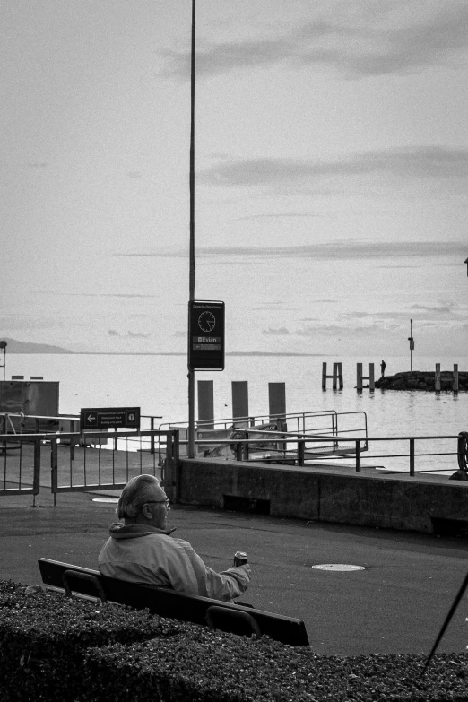 a woman sitting on a bench overlooking a body of water
