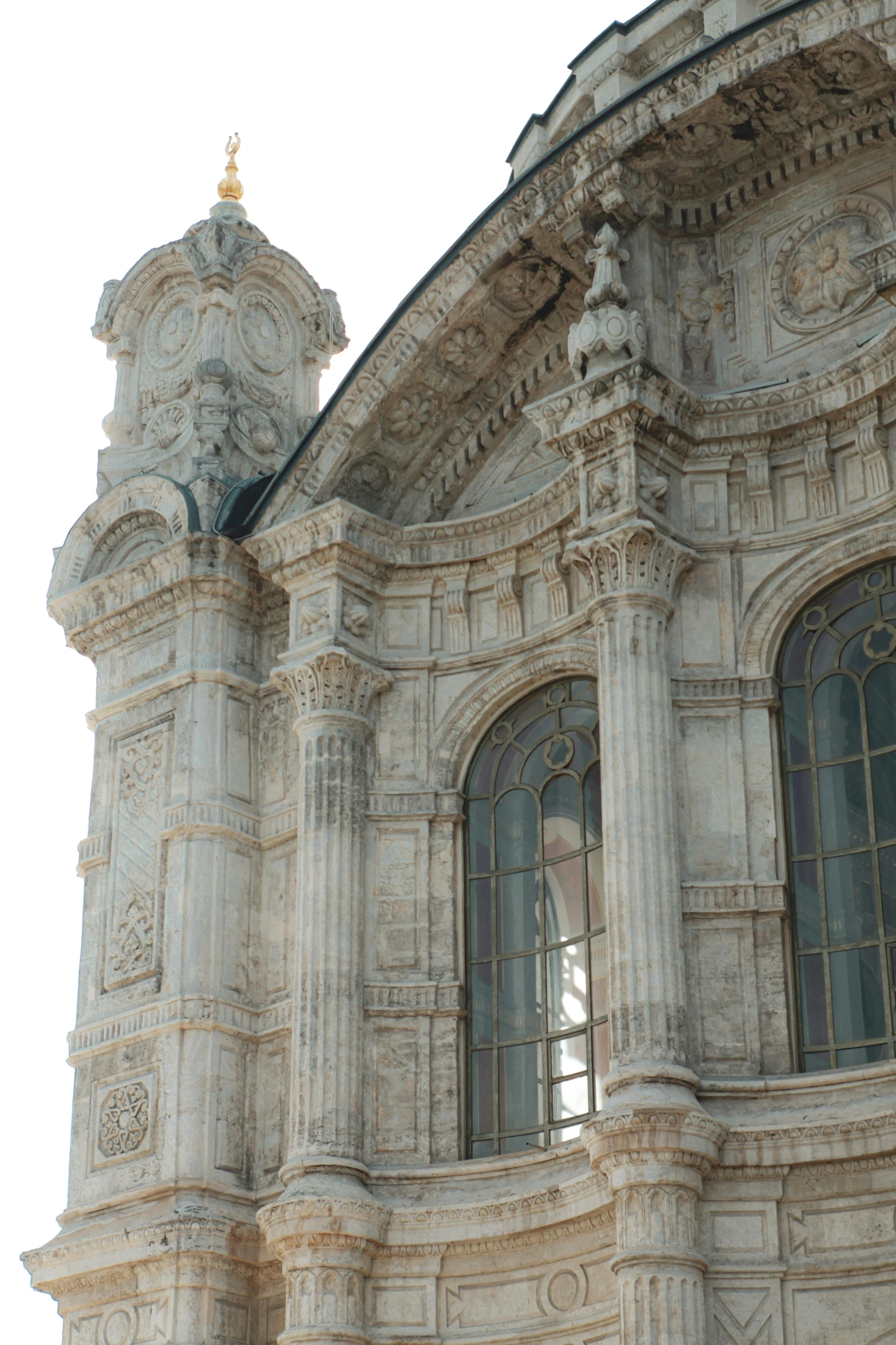 the view of a very ornate stone building through large windows