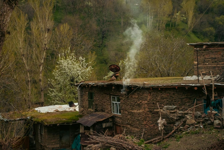 a house that is next to a hill with lots of trees in it