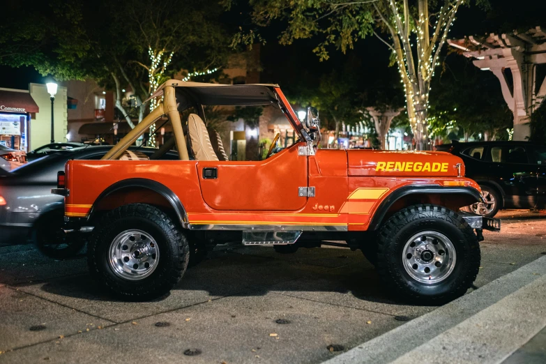 an orange jeep with an open top on the street