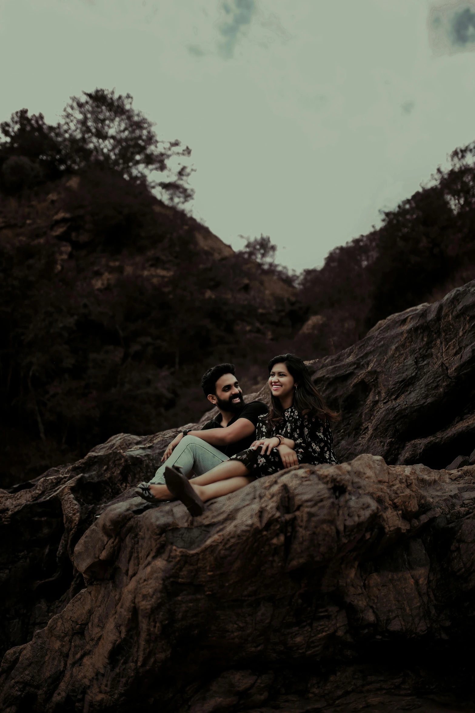 two people sitting on rocks near each other