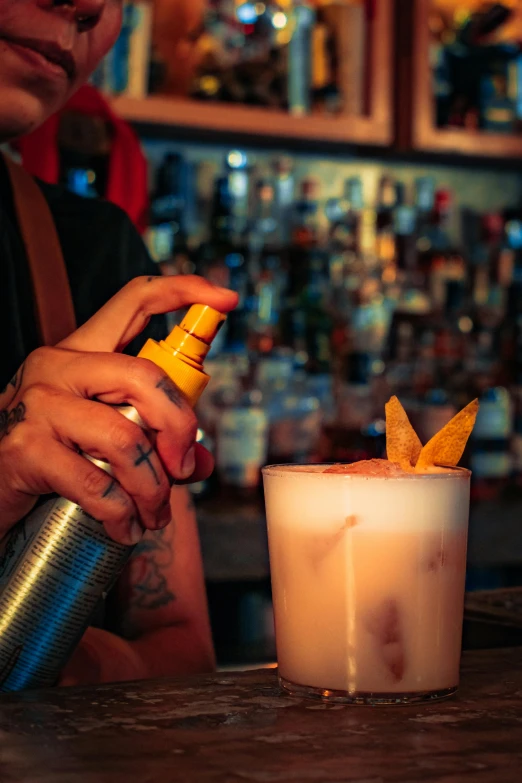 a man at a bar squeezing a drink into the glass