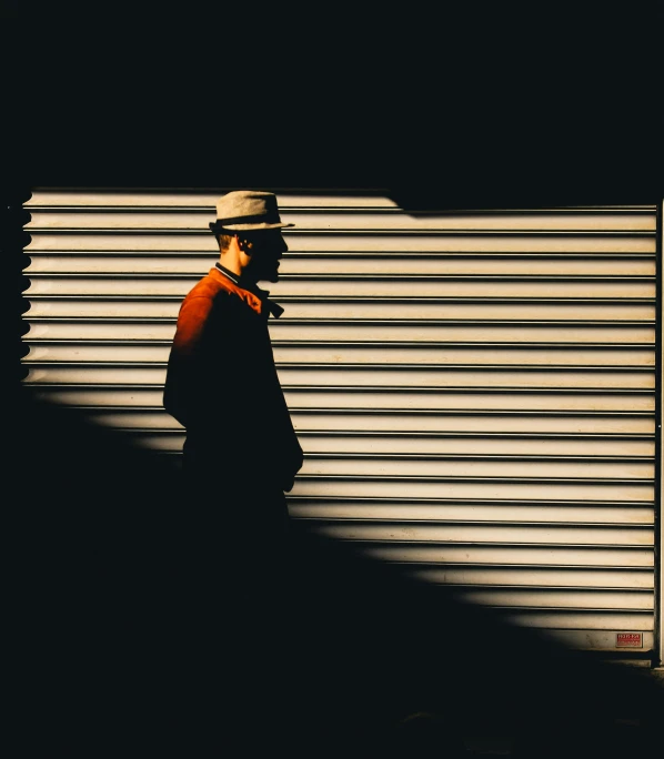 a man standing in the shadow next to a closed door