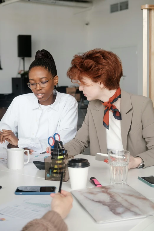 two people at a table one wearing a suit and the other wearing a scarf