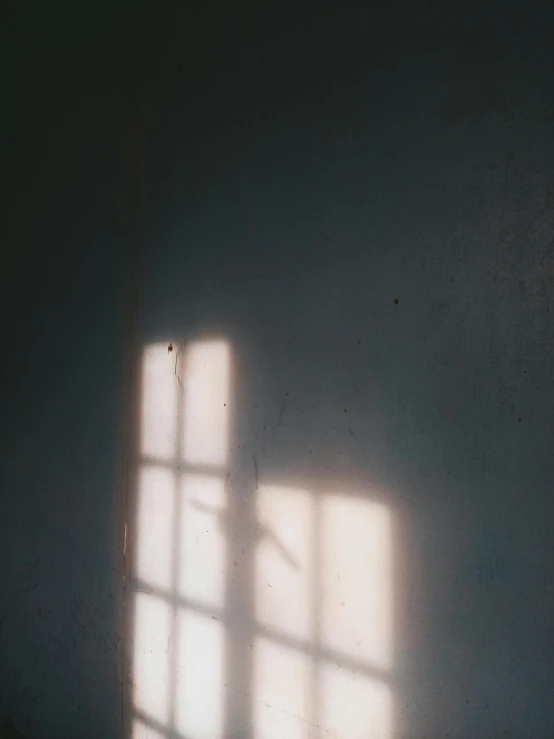 a window casts a bright light on the wall