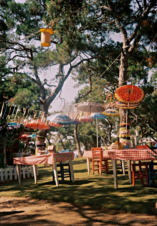 many umbrellas are hanging in a line over tables